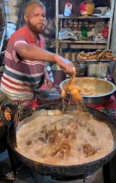 Aksi penjual fried chicken kaki lima goreng ayam pakai tangan kosong.