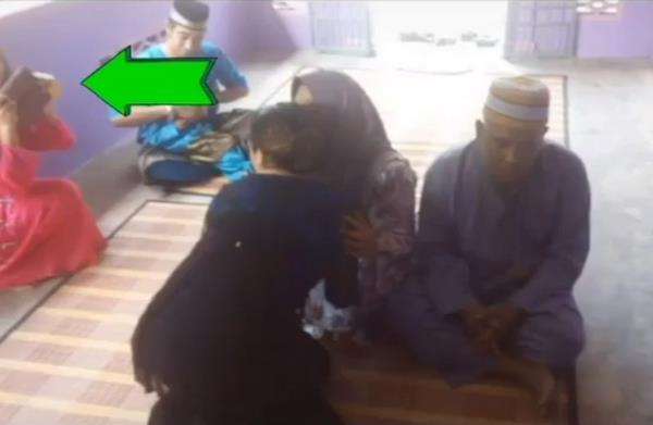 Foto diambil dari belakang, tampak sepupu Azreen sedang memotret foto seram itu.