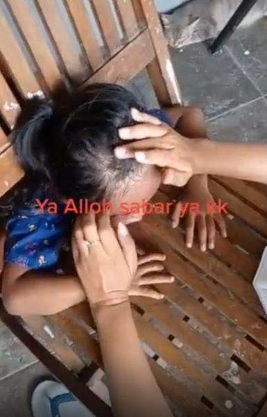 Mau ketawa tapi kasihan, kepala bocah perempuan ini kejepit kursi dan tak bisa keluar.