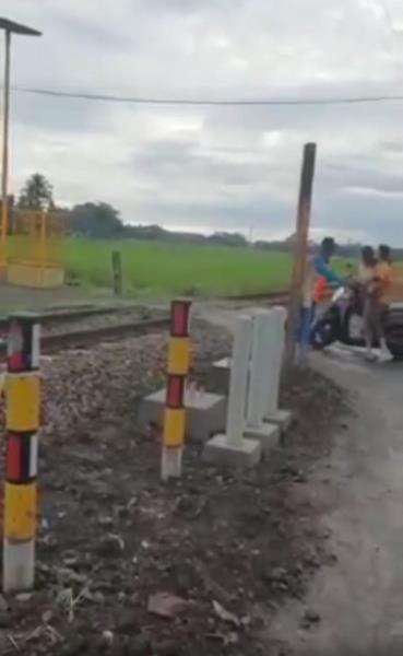 Tiba-tiba pemotor berboncengan datang mau menerobos perlintasan kereta api.