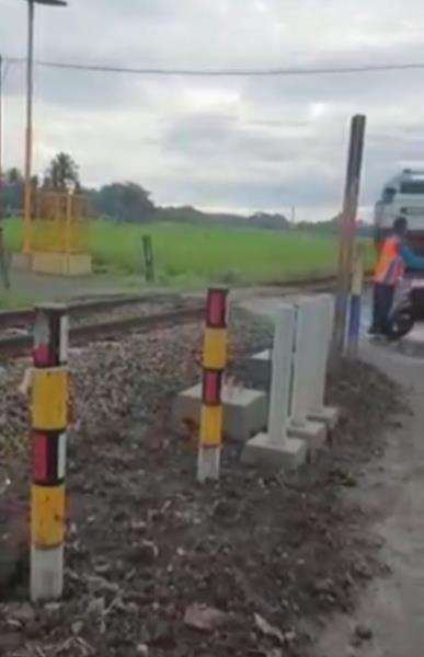 Kalau tidak ditahan, pemotor bisa ketabrak kereta api yang lewat.