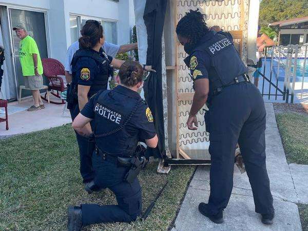 Polisi berusaha mengeluarkan ular boa dari sofa.