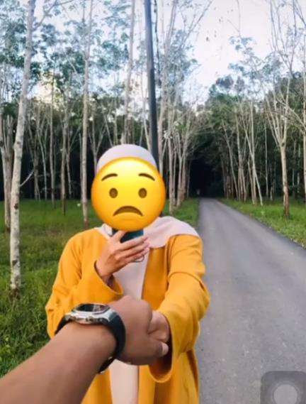 Hairee foto bersama dengan pacar dengan latar belakang kebun karet.