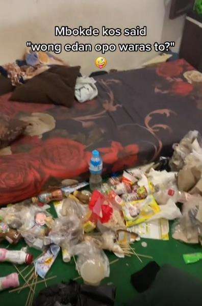 Bermacam sampah menumpuk di atas karpet dekat kasur.