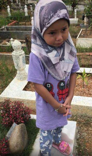 Si kakak tak bisa membendung kesedihan melihat makam adiknya.