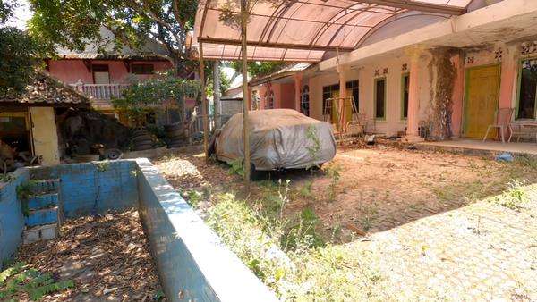 Tampak kolam renang sudah penuh dengan daun kering.