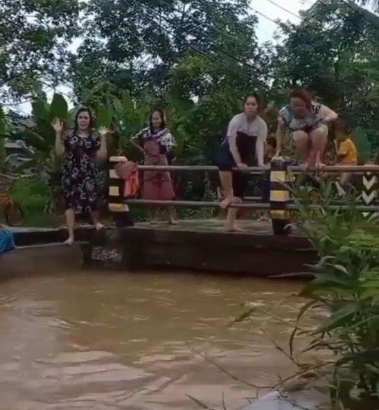 Emak-emak bersiap lompat ke dalam sungai.