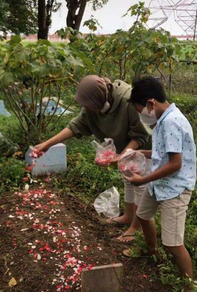 Momen tabur bunga di atas pusara mama.