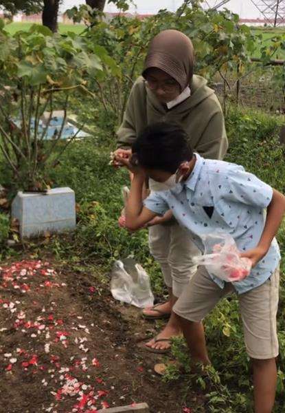 Momen tabur bunga di atas pusara mama.