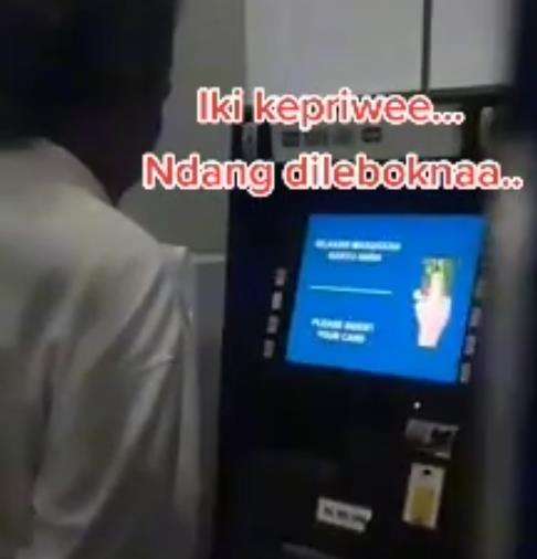 Bapak ini pandangi layar mesin ATM seolah nonton TV.