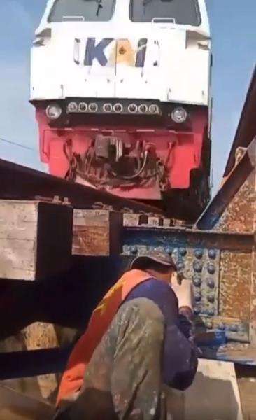 Momen mendebarkan pekerja perbaiki rel saat kereta api lewat.