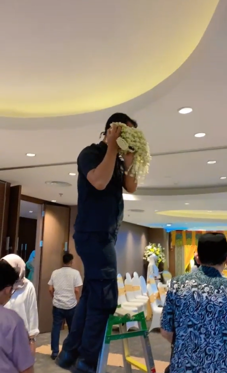 Staf Tempat Pernikahan Mengambil Rangkaian Melati untuk Pengantin