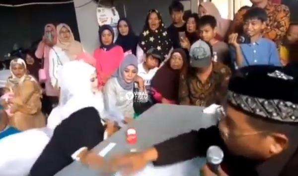 Pengantin pria pingsan di pangkuan pengantin wanita.
