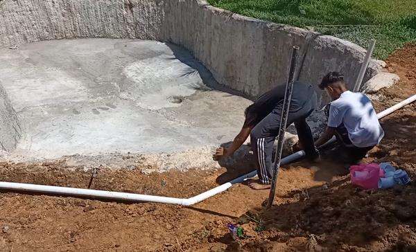 Seorang bapak bikin kolam renang sendiri dibantu anak-anaknya.