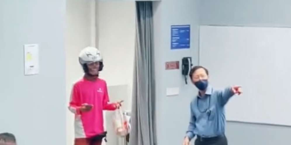Pengantar makanan bertanya pada dosen yang sedang mengajar di kelas.