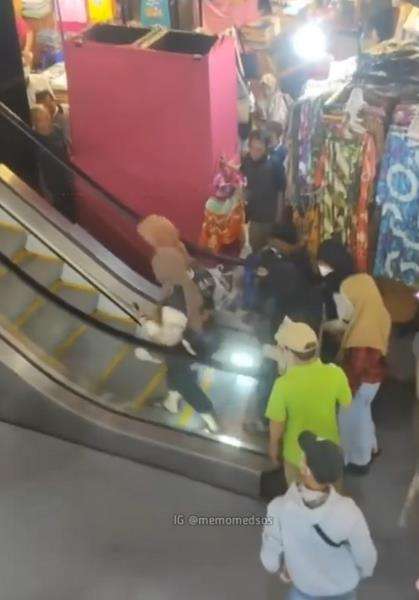 Emak-emak jatuh dan guling-guling saat naik eskalator.