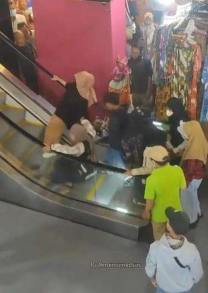 Emak-emak jatuh dan guling-guling saat naik eskalator.