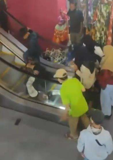Emak-emak jatuh dan guling-guling saat naik eskalator.