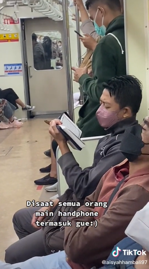 Pemuda Membaca Alquran di KRL