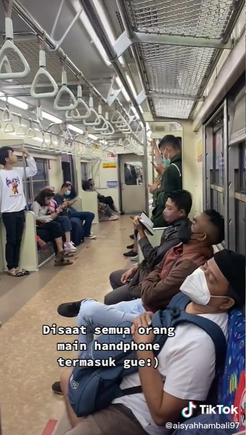 Pemuda Membaca Alquran di KRL