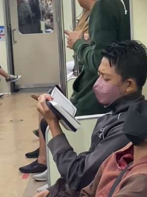 Pemuda Membaca Alquran di KRL