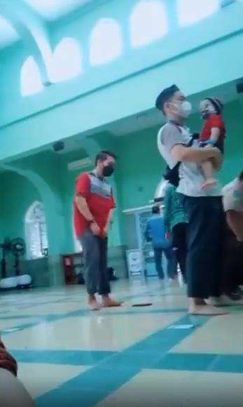 Pria sholat sambil gendong anak menuai pujian.