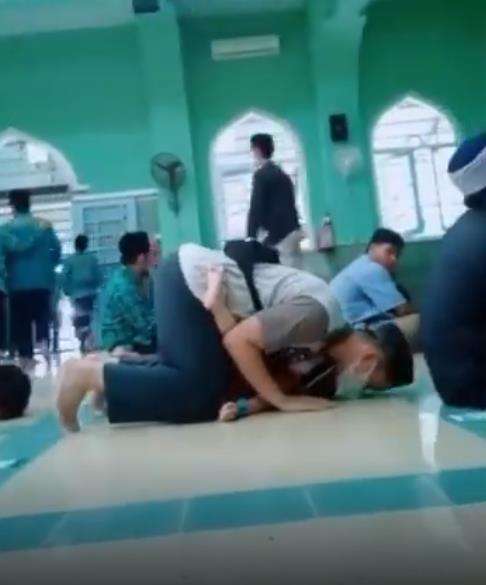 Pria sholat sambil gendong anak menuai pujian.
