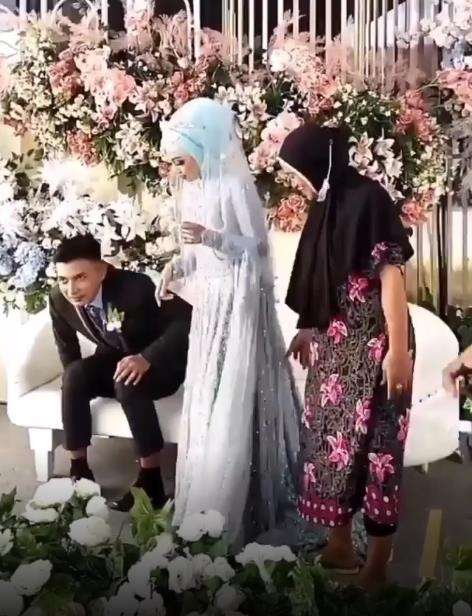 Viral emak-emak dasteran foto bareng pengantin di pelaminan.
