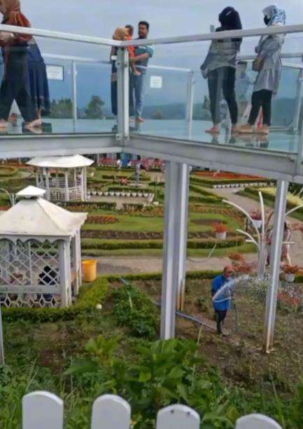 Nikmatnya jembatan kaca malah fokus ke tukang kebun di bawahnya.