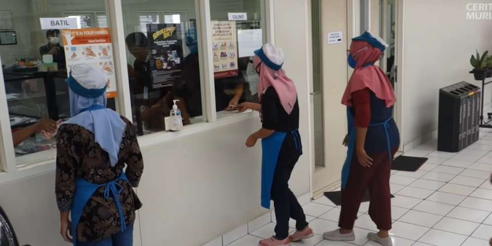 Para buruh mengantre di loket untuk mengambil THR
