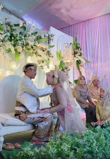 Momen pengantin pria hendak cium bibir istri di atas pelaminan.