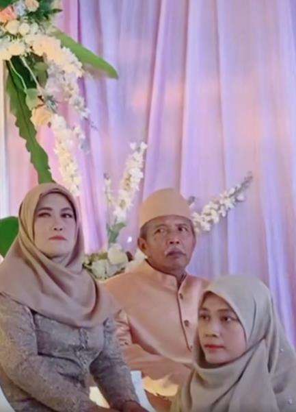 Momen pengantin pria hendak cium bibir istri di atas pelaminan.