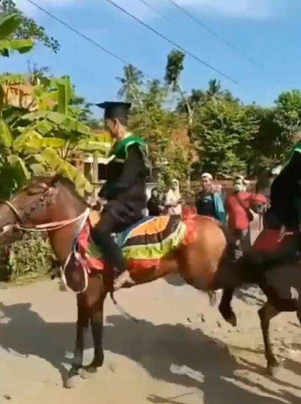Wisudawan diarak keliling kampung naik kuda.