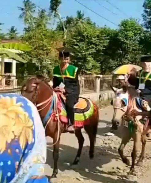 Wisudawan diarak keliling kampung naik kuda.