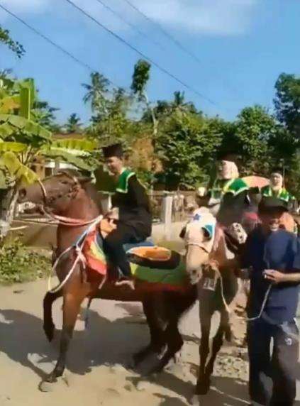 Wisudawan diarak keliling kampung naik kuda.