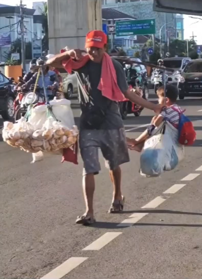 Ayah panggul anaknya sambil berdagang Ayah panggul anaknya sambil berdagang