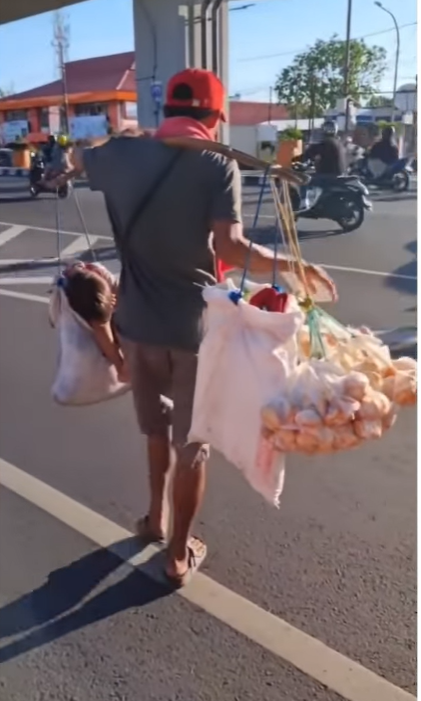 Ayah panggul anaknya sambil berdagang Ayah panggul anaknya sambil berdagang