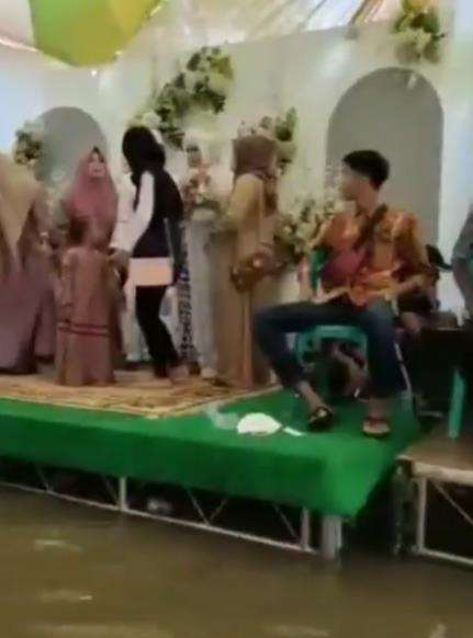 Viral resepsi pernikahan tetap digelar walaupun rumah dikepung banjir.
