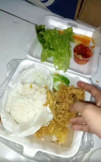Makan nasi ayam penyet di warung kaki lima.