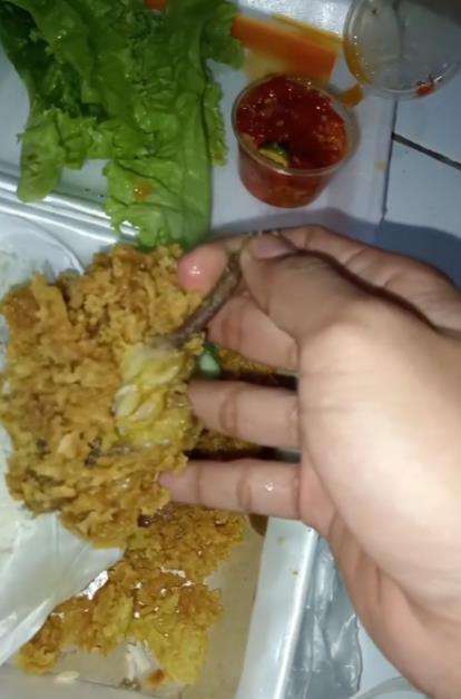 Makan nasi ayam penyet di warung kaki lima.