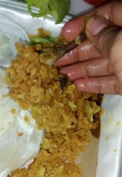 Makan nasi ayam penyet di warung kaki lima.