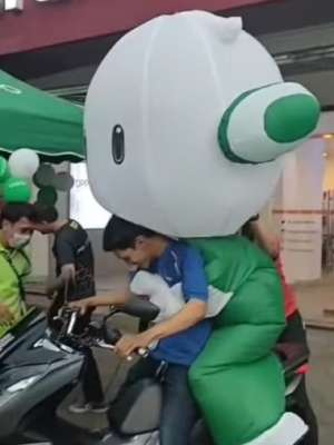 Maskot Oppo dibonceng naik motor. Maskot Oppo dibonceng naik motor.
