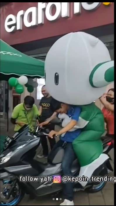 Maskot Oppo kesulitan naik motor Maskot Oppo kesulitan naik motor
