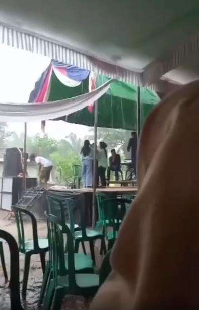 Lagi dangdutan di atas panggung saat hujan deras, disambar petir.