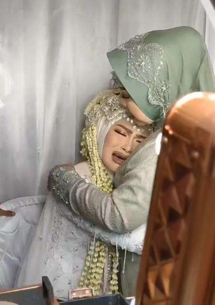 Tangis pengantin wanita kembali pecah saat dipeluk saudaranya.