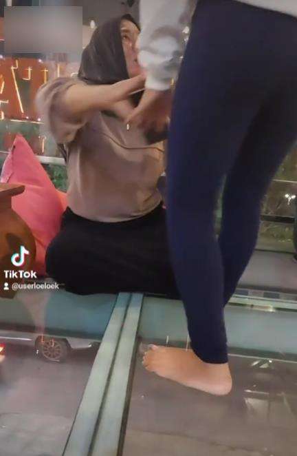 Emak-emak ngesot di lantai kaca.