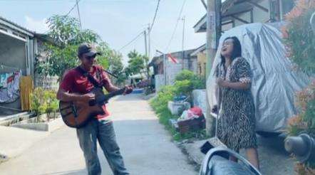 Emak-emak duet dengan pengamen.