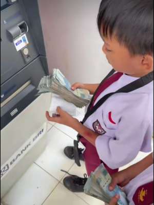 2 bocah ambil segepok uang di mesin ATM.