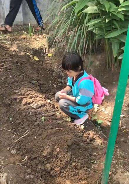 Bocah berdoa di samping gundukan tanah.