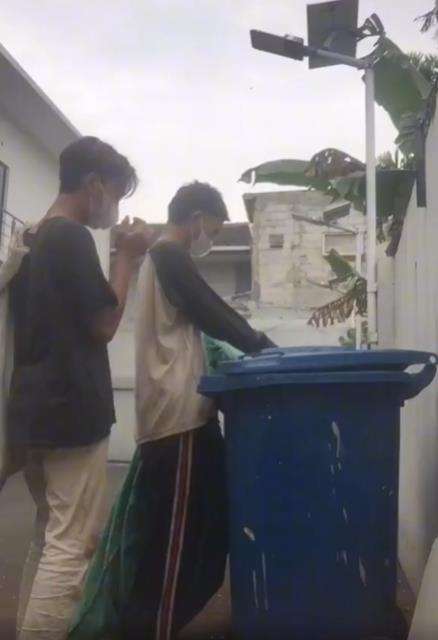 Dua pemuda makan dari tempat sampah.